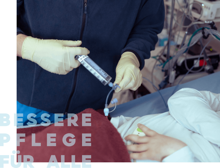 Eine Pflegekraft verabreicht mit einer Spritze eine Behandlung an einem Patienten im Krankenhaus.