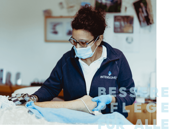 Eine Pflegekraft mit Maske kümmert sich aufmerksam um einen Patienten in einer häuslichen Umgebung.
