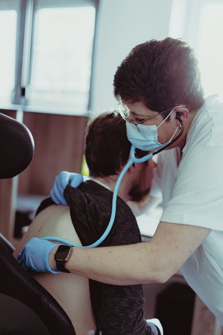 Eine Pflegerin führt eine Untersuchung bei einem Patienten in einem modernen Zuhause durch.